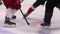 Judge throws puck to start hockey game on ice rink