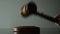 Judge woman strikes with a hammer on the stand, light background, close-up