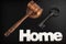 Judges Hammer or Gavel With Home Sign On Dark Background