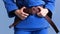 Judo girl with brown belt. A judoka teenager fighter poses in a blue kimono on a plain background. Japanese martial art.