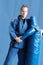 Judo girl with brown belt. A judoka teenager fighter poses in a blue kimono on a plain background. Japanese martial art.