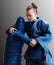 Judo girl with brown belt. A judoka teenager fighter poses in a blue kimono on a plain background. Japanese martial art.