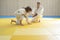 Judo master and young yellow belt judo girl are training