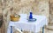 A jug of holy water, a jug of oil and a donation basket are on the table during a collective prayer in Emmaus Nicopolis