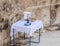 A jug of holy water, a jug of oil and a donation basket are on the table during a collective prayer in Emmaus Nicopolis