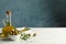 Jug with olive oil and bowl with olives on table, space for text