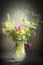 Jug with wild field flowers bunch on rustic table