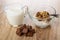 Jug with yogurt, bowl with granola, yogurt, chocolate, pieces of porous chocolate on table