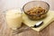 Jug with yogurt, bowl with muesli on napkin, spoon on wooden table