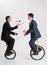Juggling businessmen riding unicycles