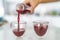 Juice bottle beet drink smoothie woman pouring drinks in cups at home kitchen. Closeup of two glasses with red vegetable