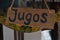 A juice stand with a sign offering Jugos
