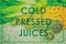 Juice text as title on poster. Words COLD PRESSED JUICES for advertising sign over picture of fresh vegetables. Detox