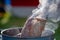 Juicy Angus steak frying in iron cast pan with smoke and Tongs on blurred nature background , cooking party picnic outdoor