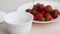 Juicy appetizing tasty strawberry on a white plate with sugar bowl.