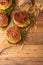 Juicy burgers with beef, cheese, lettuce, onions, tomatoes, cucumbers, buns and sauce cooked on a grill. Cheeseburger on a wooden