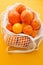 Juicy citruses: oranges, tangerines in an eco bag on an orange summer background