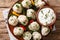 Juicy cooked khinkali dumplings with sour cream, pepper and herbs closeup on a plate. Horizontal top view