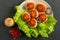 Juicy delicious coated with breadcrumbs and fried chicken cutlets on white plate with spices and cetchup on dark background, view