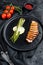 Juicy duck breast steaks with caramelized asparagus. Black background. Top view