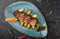 Juicy duck breast steaks with caramelized fruit, mango, apple and sauce of orange on plate over dark stone background. Hot Meat