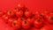 Juicy fresh delicious tomatoes fall on a mountain of vegetables on a red background. Food videos
