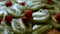 Juicy fresh kiwi slices and frozen red currant arranged in a shape of Christmas tree on a black marble cutting board