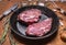 Juicy fresh raw pork steak old cast iron pans with a knife for meat fork herbs and spices garlic wooden rustic background c