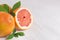 Juicy fresh round slice pink grapefruit macro with green leaf, copy space.