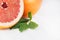 Juicy fresh round slice pink grapefruit macro with green leaf, copy space.