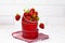 Juicy Fresh Strawberries in a Red Bowl on a piece of cloth on a white Brick background. Vitamin food. Copy space