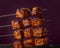 Juicy Grilled Barbecue Chicken Cubes on Skewers with Smoky Flavor on Dark Background