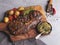 Juicy grilled beef steak with bone, potatoes,  tomato  wooden board sauce pesto