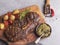 Juicy grilled beef steak with bone, potatoes,  tomato  wooden board sauce pesto