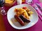 Juicy grilled creole sausages served with vegetables and potatoes