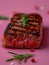 Juicy Grilled Steak Medium Rare with Char Marks and Rosemary on a Pink Background