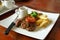 Juicy grounded pork steak with tomato serving with potato chips and black pepper sauce