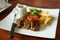 Juicy grounded pork steak with tomato serving with potato chips and black pepper sauce