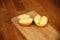 Juicy halved apple on a cutting board on a wooden surface