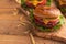 Juicy homemade french fries burgers. Wooden texture with space for design. Delicious and fast food