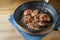 Juicy lamb fillets freshly fried in a pan and served on a wooden table, copy space