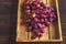 Juicy large bunch of grapes in a wooden box close-up. Ripe grapes and copy space. An abundance of grapes with grape seed