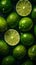 Juicy limes, some whole and some halved, covered in droplets of water against a dark background.