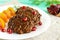 Juicy liver cutlets with pomegranate seeds on a white plate.