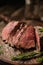 Juicy medium Beef Rib Eye steak slices on wooden board with herbs spices and salt