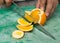 A juicy orange being sliced into segments on a green fruit and vegetable chopping board. organic fruit and vegetables