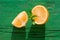 Juicy orange slices with mint leaves  on wooden green background with hard light, on strong sunlight