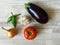 Juicy organic green peppers, red tomato, purple eggplant, yellow onion  and white garlic top view  photo. Summer vegetables.