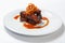 Juicy piece of lamb under red sweet sauce and covered with fried onion on large round white plate on white background.