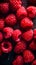 Juicy red raspberries with water droplets on a dark background.